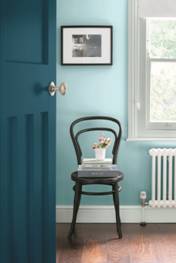 A black and white picture frame adorns a light turquoise wall. I can't get over that beautiful teal door! This can all be done with Valspar Reserve paint.