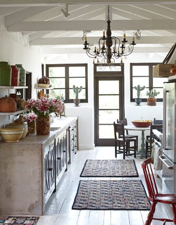 McDowell put poured-concrete counters on reproduction 17th-century cabinets by Marcia Bland Brown: "The concrete is practical as well as earthy. I can set hot pans on it." The Early American hooked rugs are from East Meets West Antiques. Cast-iron urns and salt-glaze pots are from Charme d'Antan. Circa Home Living chandelier. Read more: Spanish Style Homes - Country House Decorating - House Beautiful