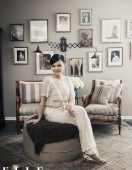 Goodwin poses in her serene antique filled living space "wearing Valentino, poses with photos of her vaudevillian great-aunt." Hilary Walsh / ELLE