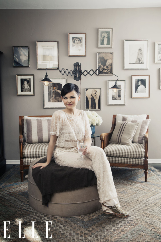 Goodwin poses in her serene antique filled living space "wearing Valentino, poses with photos of her vaudevillian great-aunt." Hilary Walsh / ELLE