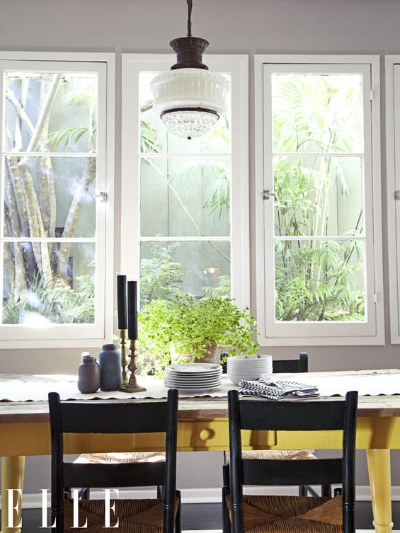 Ginnifer's bright yellow kitchen table and lovely black chairs face her picturesque paned window and lovely view! Photo credit: Hilary Walsh / ELLE 