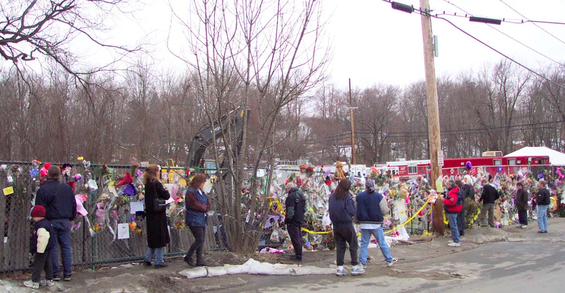 People pay tribute to the 100 lives that were lost at the Station Nightclub fire on February 20, 2003.