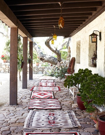 "Front Porch Antique Navajo rugs form a path on the front porch of designer Kelley McDowell's 1920 farmhouse in Ojai, California. She gathered the stones from her property to build the porch: "It looks like a 3,000-year-old road in Rome." Read more: Spanish Style Homes - Country House Decorating - House Beautiful "