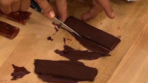 "The Chew" chef Michael Symon trims his happy bars after dipping the candies in chocolate. Yum!