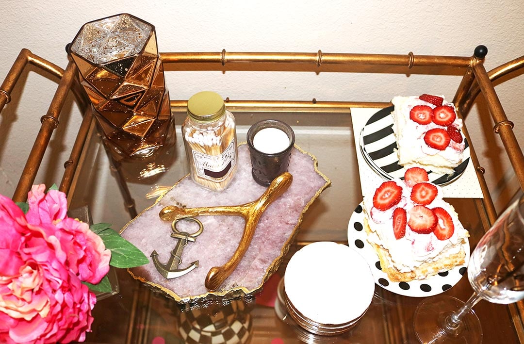 candace rose anderson valentine's day bar cart decorated with an agate cheeseboard, kate spade stripe and polka dot dessert plates and angel food cake, an anchor bottle opener, mercury glass candle, matches, coasters. candieanderson.com