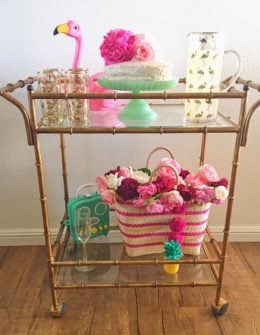 Lifestyle blogger Candace Rose Anderson of the blog Candie Anderson adorned her gold faux bamboo bar cart with flamingo decor must haves, garden roses, and a straw tote for summer!