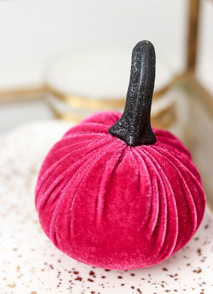 Candie Anderson shares a cute pink velvet pumpkin with a black glitter stem. It looks great on her glam fall bar cart.