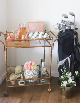 Lifestyle blogger Candie Anderson of the website Candieanderson.com shares her gold faux bamboo bar cart filled with RoseCandi fresh garden roses, Mackenzie Childs black and white courtly check egg plate, golf balls, decor and a golf bag.