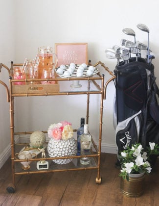 Lifestyle blogger Candie Anderson of the website Candieanderson.com shares her gold faux bamboo bar cart filled with RoseCandi fresh garden roses, Mackenzie Childs black and white courtly check egg plate, golf balls, decor and a golf bag.
