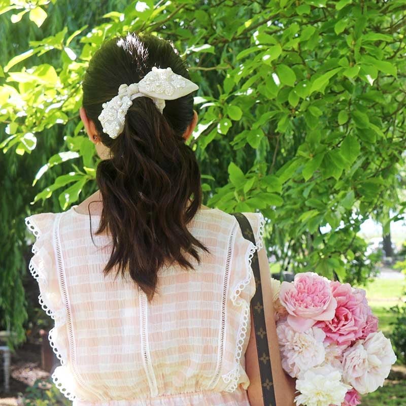 Style expert and fashion blogger, Candie Anderson of candieanderson.com has the scoop on the best bow scrunchies including the Deepa Gurnani Blaire bow scrunchie in ivory with pearl embellishments.