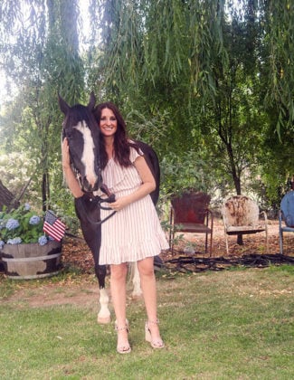 bb dakota sweet tart dress in white pink red stripes worn by Candie Anderson of candieanderson.com. She posed with Dillon the horse to dish on the best one shoulder dresses for summer.