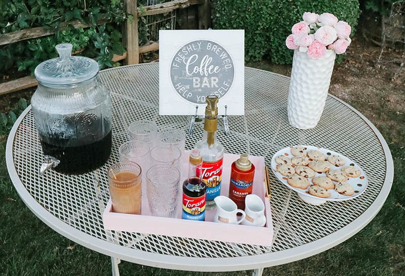 Lifestyle expert Candie Anderson shares the secret to creating a fun vintage chic coffee bar with a cute coffee bar sign, a beverage dispenser, glasses, Torani syrups, cookies, fresh flowers and more.