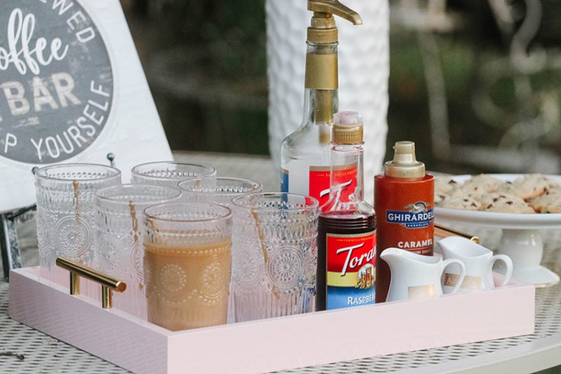 Lifestyle expert and blogger, Candie Anderson has the scoop on how to create a vintage chic coffee bar with a light pink Kate and Laurel tray, clear glasses, Torani syrup, caramel sauce and creamers.
