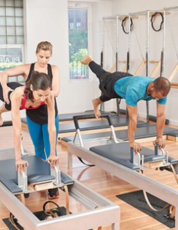 Certified Pilates Instructor Adrianne Yurgosky teaching push ups on the reformer. Photo Credit: Michel Leroy