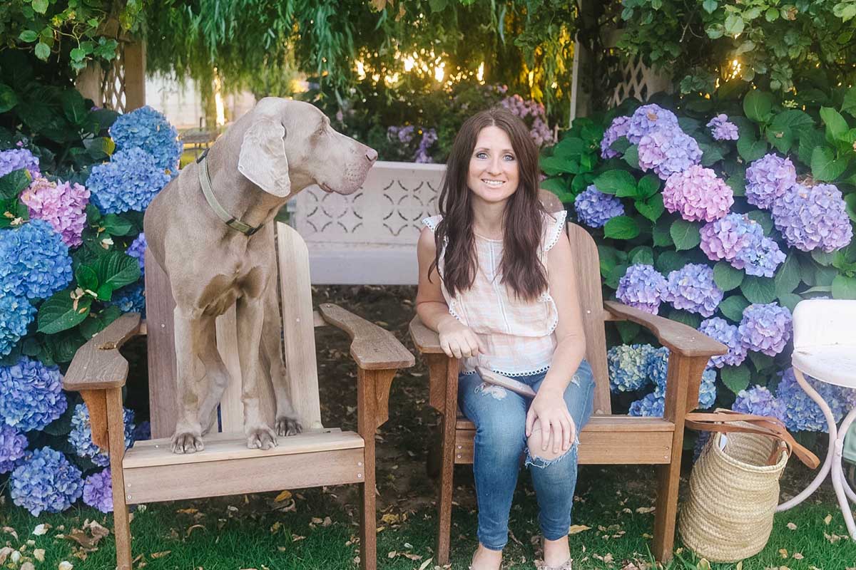 Lifestyle expert, journalist, interior design blogger and dog mom Candie Anderson of candieanderson.com with her Weimaraner Fred on their Adirondack chairs.