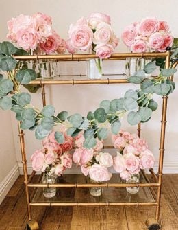 Lifestyle expert Candie Anderson of candieanderson.com shares the top spring garlands including this beautiful faux eucalyptus garland adorning her gold bar cart which is filled with pink Eden garden roses.
