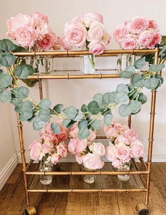 Lifestyle expert Candie Anderson of candieanderson.com shares the top spring garlands including this beautiful faux eucalyptus garland adorning her gold bar cart which is filled with pink Eden garden roses.
