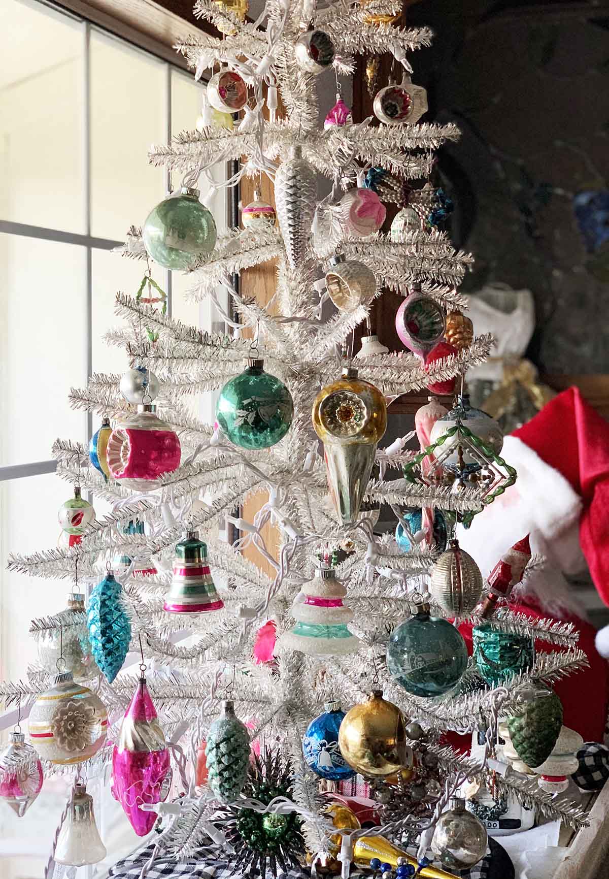 Living expert Candie Anderson's mom's silver tinsel sparse Christmas tree decorated with vintage Christmas ornaments.