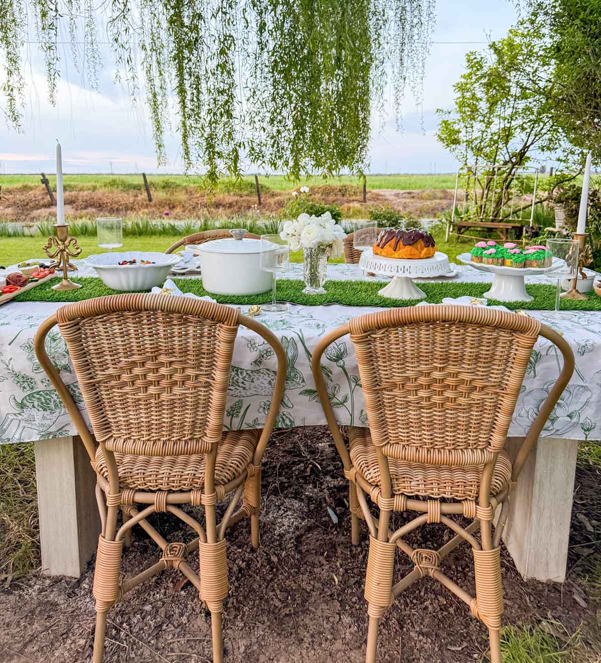 Entertaining expert, journalist and lifestyle blogger Candie Anderson of candieanderson.com shows you how to create two beautiful Easter tablescapes including this gorgeous botanical Easter tablescape with a green tablecloth and faux grass table runner.