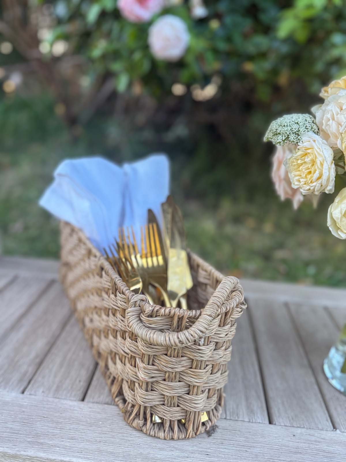 Entertaining expert, Candie Anderson shares her faux bamboo gold flatware, white cloth napkins in her rattan flatware caddy.