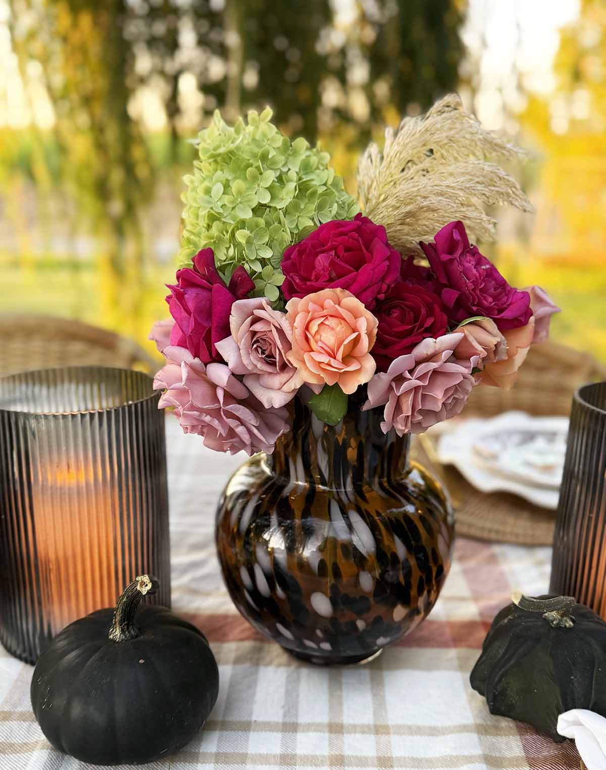 Entertaining expert, journalist, blogger and flower farmer Candie Anderson shares her tortoiseshell vase filled with hydrangeas, garden roses and pampas grass on her outdoor fall tablescape.