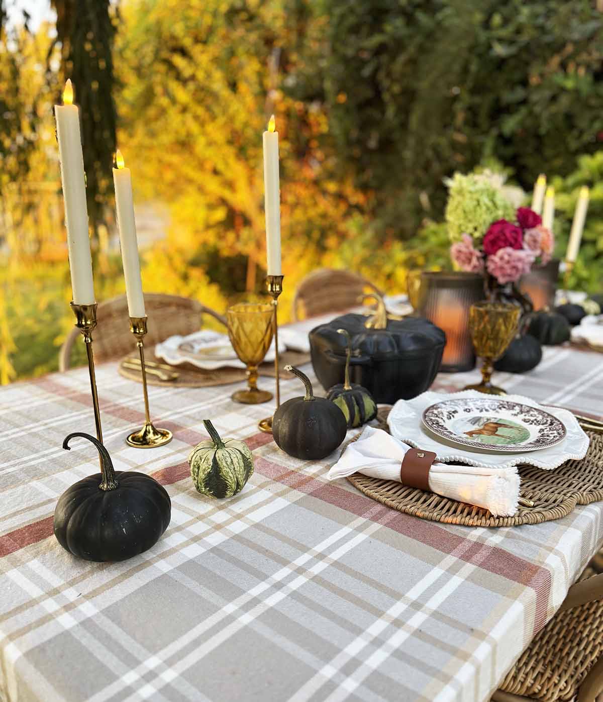 Entertaining expert, Candie Anderson shares how she decorated her outdoor fall tablescape with pumpkins, gourds, brass candle holders, equestrian plates, gorgeous flowers and more!