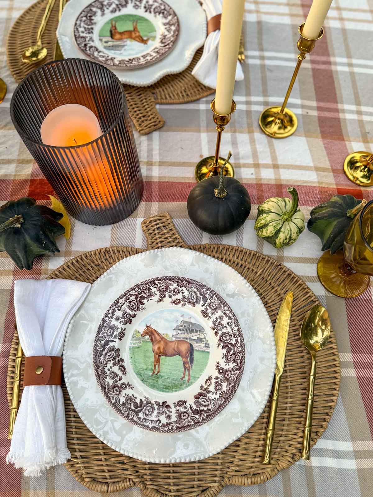 Entertaining expert, Candie Anderson of candieanderson.com shares her layered fall place setting, which includes a rattan pumpkin shaped placemat, white Perlette melamine plates, horse plates, white cloth napkins and leather napkin rings.