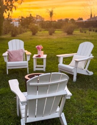 Entertaining expert, journalist and lifestyle blogger Candie Anderson of candieanderson.com shows you how to create a cozy Valentine's Day outdoor hosting idea with white foldable Adirondack chairs and faux fur throw pillows in light pink and cream, and a smokeless fire pit.