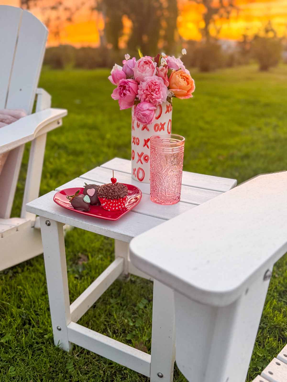 Entertaining expert, journalist and lifestyle blogger Candie Anderson of candieanderson.com shares how she adorned her white classic outdoor side table (next to her Adirondack chairs) with delicious desserts and pretty homegrown flowers for Valentine's Day.