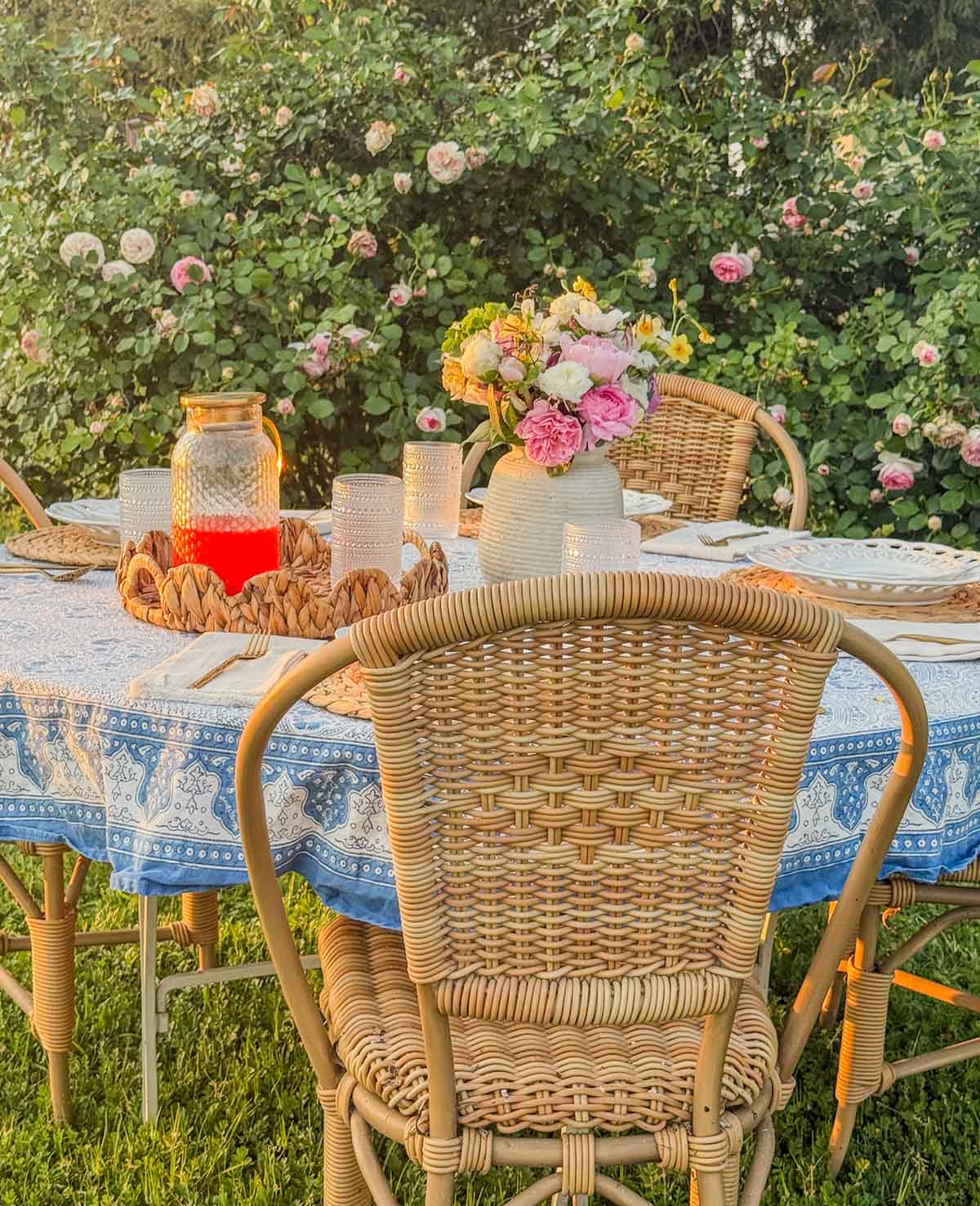 Entertaining expert, journalist and lifestyle blogger Candie Anderson of candieanderson.com shares how she styled her outdoor dining table with a beautiful tablecloth, gorgeous flowers from her flower farm, a timeless table setting and her wicker bistro chairs.