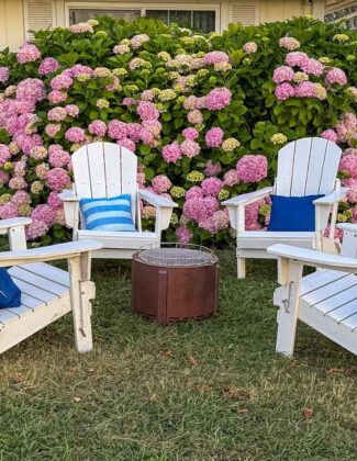 Lifestyle expert, journalist and interior design blogger Candie Anderson of candieanderson.com shares the best white outdoor Adirondack chairs with blue stripe pillows and navy throw pillows and a smokeless fire pit.