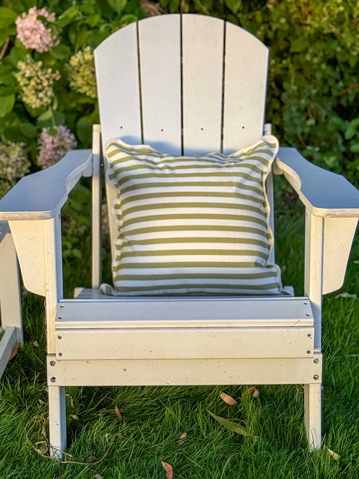 Lifestyle expert, journalist and interior design blogger Candie Anderson of candieanderson.com shares her white Beachcrest Home Shawnna Adirondack Chair, which is adorned with green and white scalloped throw pillows.