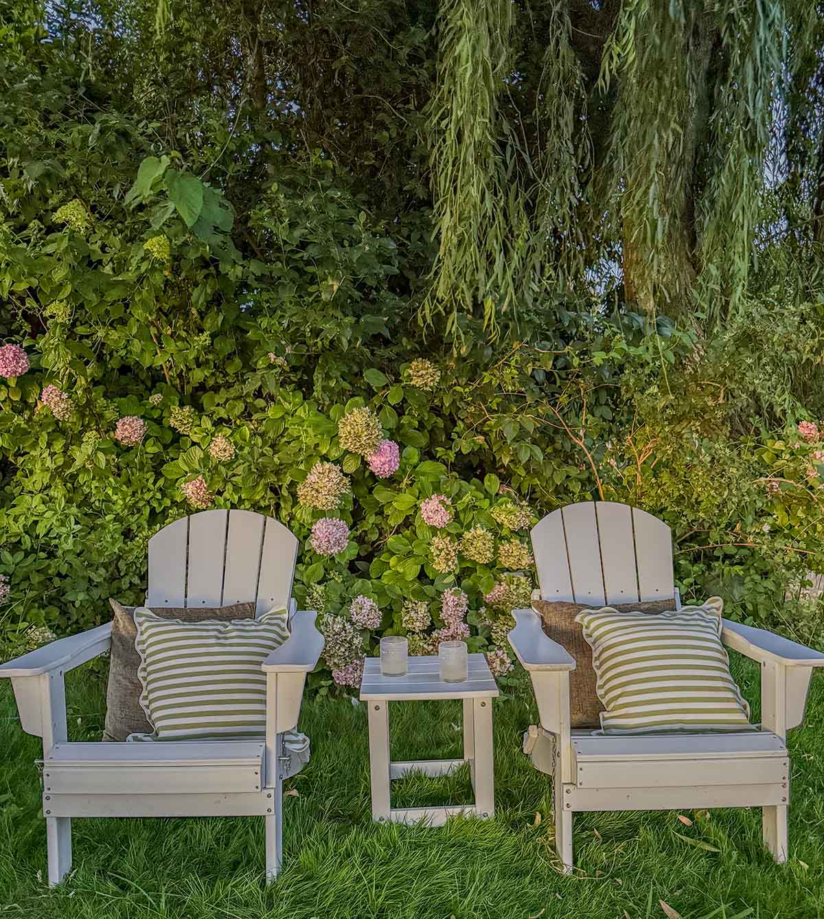 Wade Logan Laguna Adirondack Set adorned with scalloped green and white stripe throw pillows and solid color throw pillows. best outdoor seating for summer