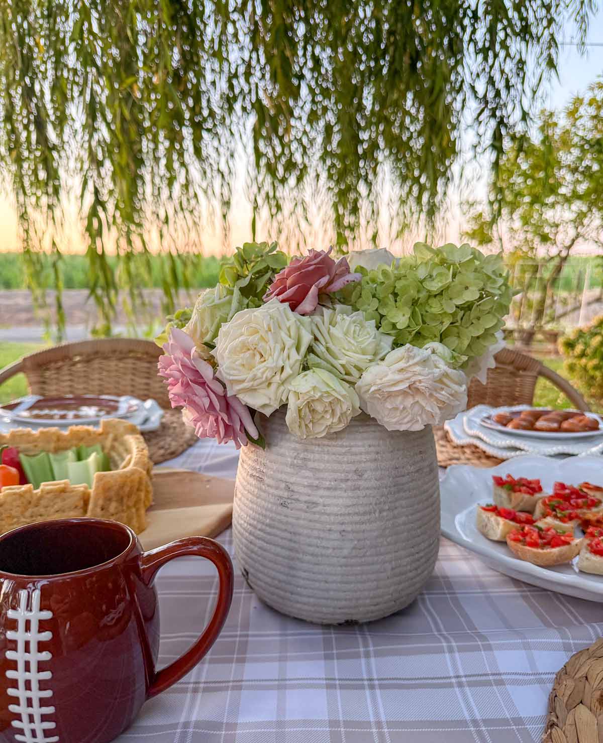 Entertaining expert, journalist and lifestyle blogger Candie Anderson of candieanderson.com shares the beautiful ceramic vase filled with garden roses and hydrangeas on her football tailgate tablescape.