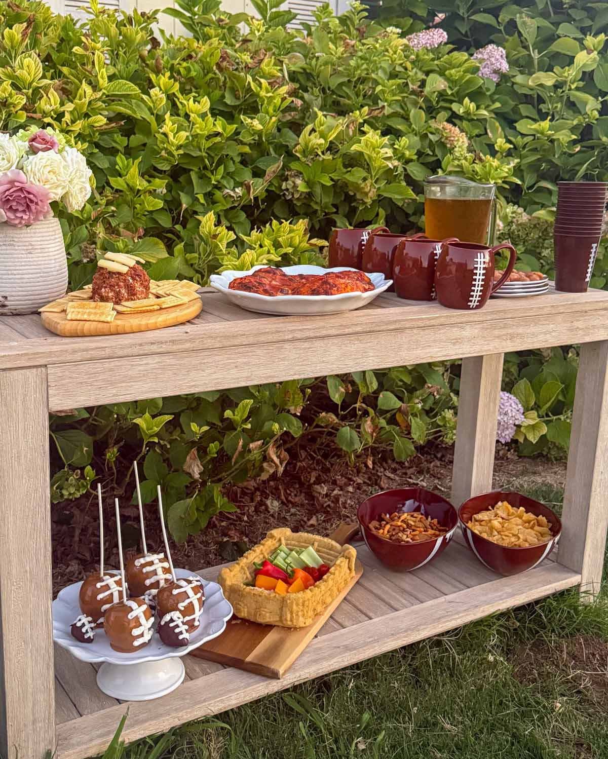 Entertaining expert, journalist and lifestyle blogger Candie Anderson of candieanderson.com shares how she adorned her two tier outdoor console table with football inspired food, football shaped food and football entertaining essentials and used it as a buffet at her tailgate party.