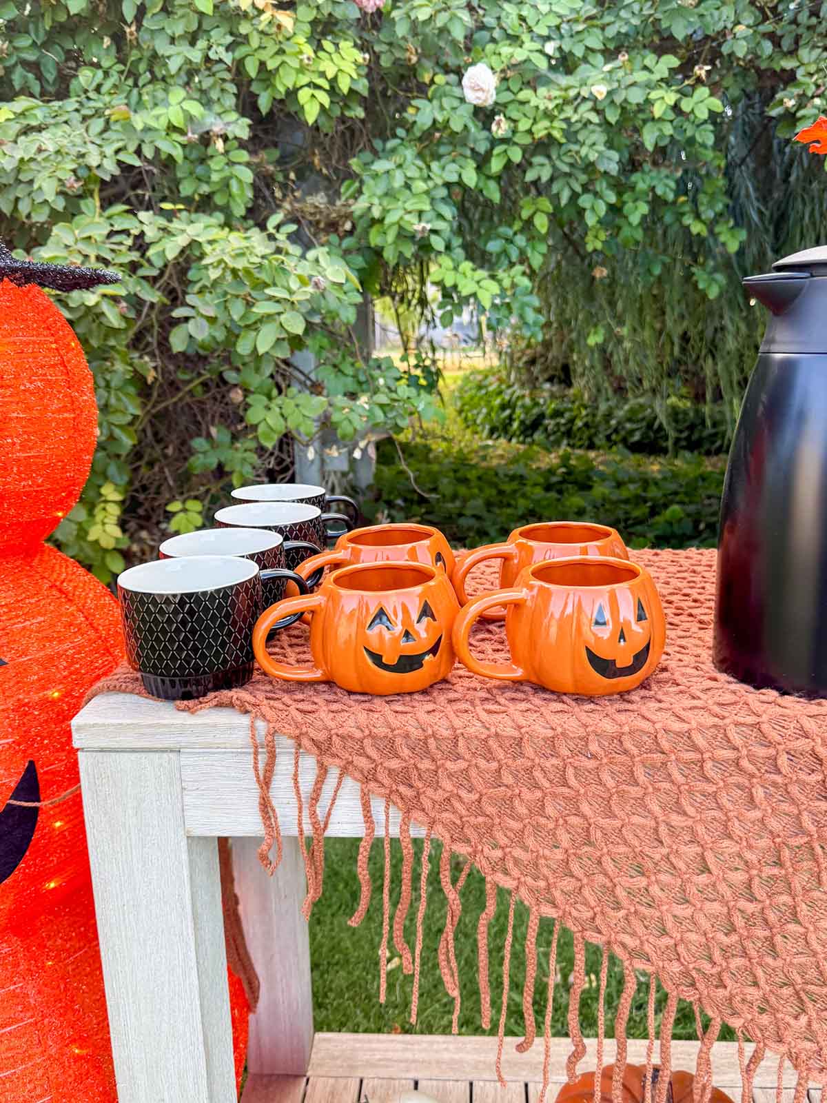 Entertaining expert, journalist and lifestyle blogger Candie Anderson of candieanderson.com shares how she adorned her outdoor Halloween coffee bar with black and pumpkin shaped coffee mugs.