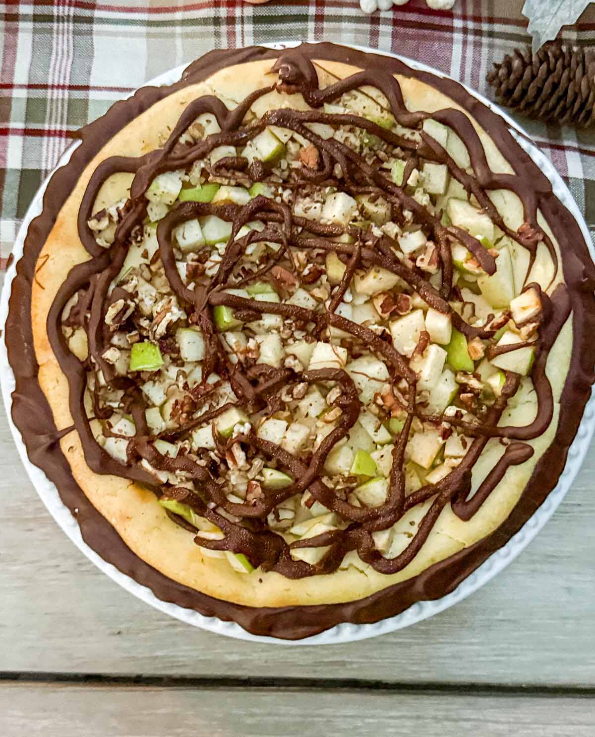 Enertaining expert, journalist and lifestyle blogger Candie Anderson of candieanderson.com shares a closeup of her beautiful chocolate cheesecake adorned with Granny Smith apples and chopped pecans on her fall tablescape.