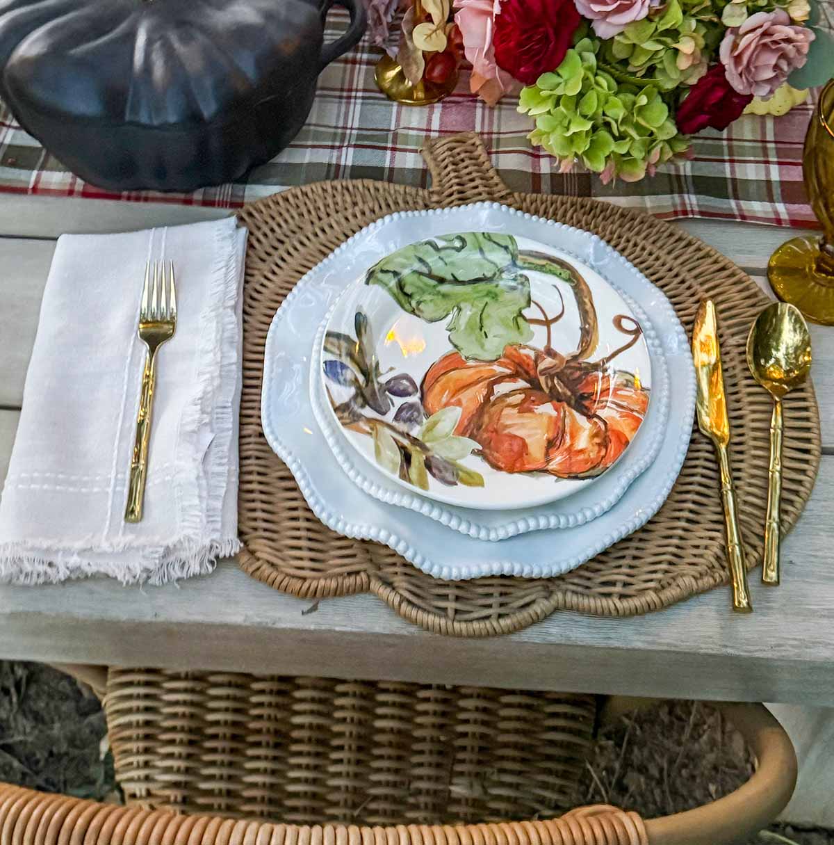 Entertaining expert, journalist and lifestyle blogger Candie Anderson of candieanderson.com shares how she created her beautiful fall tablescape with gold flatware, neutral fringe napkins, rattan pumpkin shaped placemats, white dinnerware, and pumpkin salad plates.