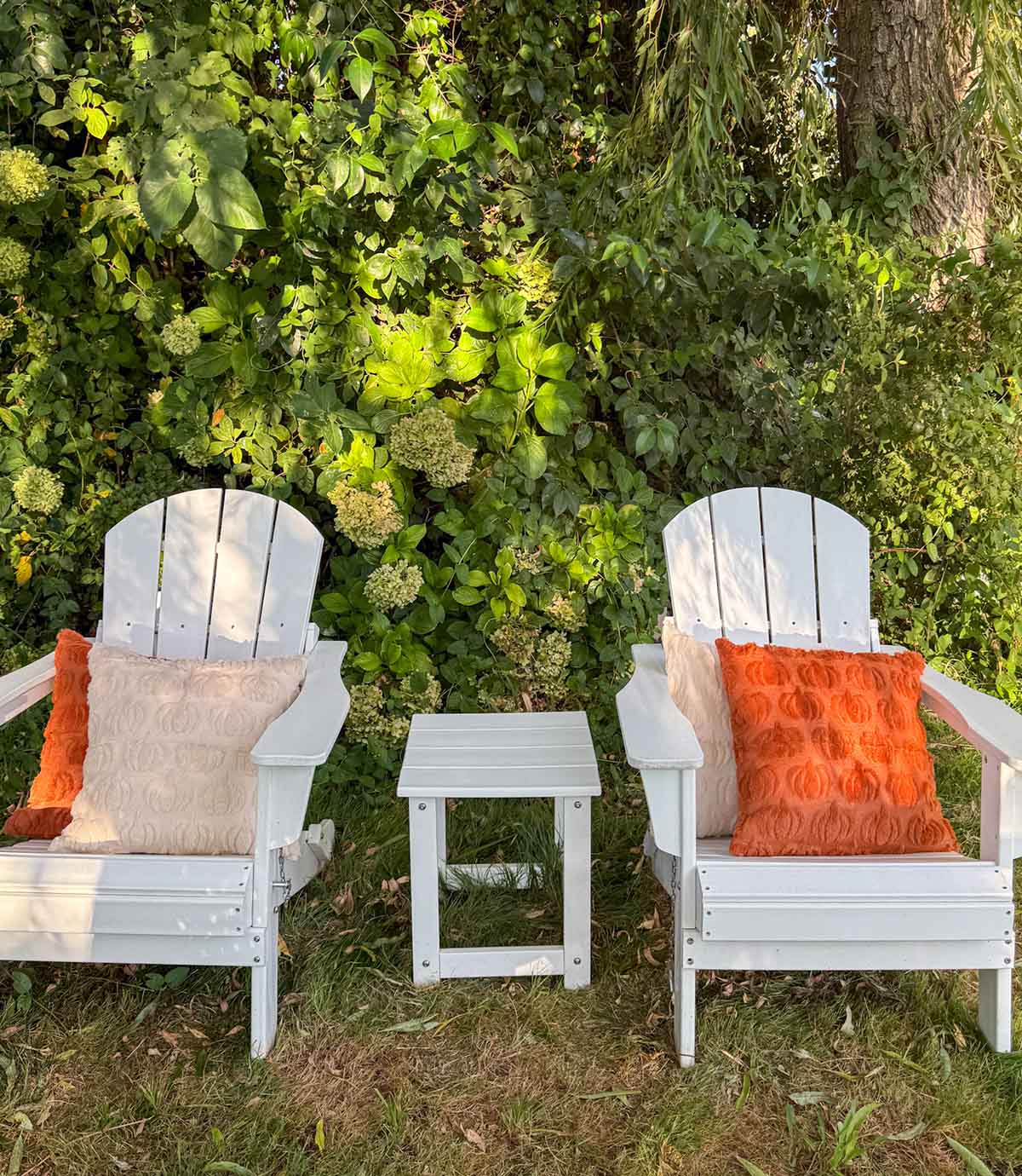 Entertaining expert, journalist and lifestyle blogger Candie Anderson of candieanderson.com shares the best white foldable Adirondack chairs adorned with rust and beige pumpkin throw pillows.