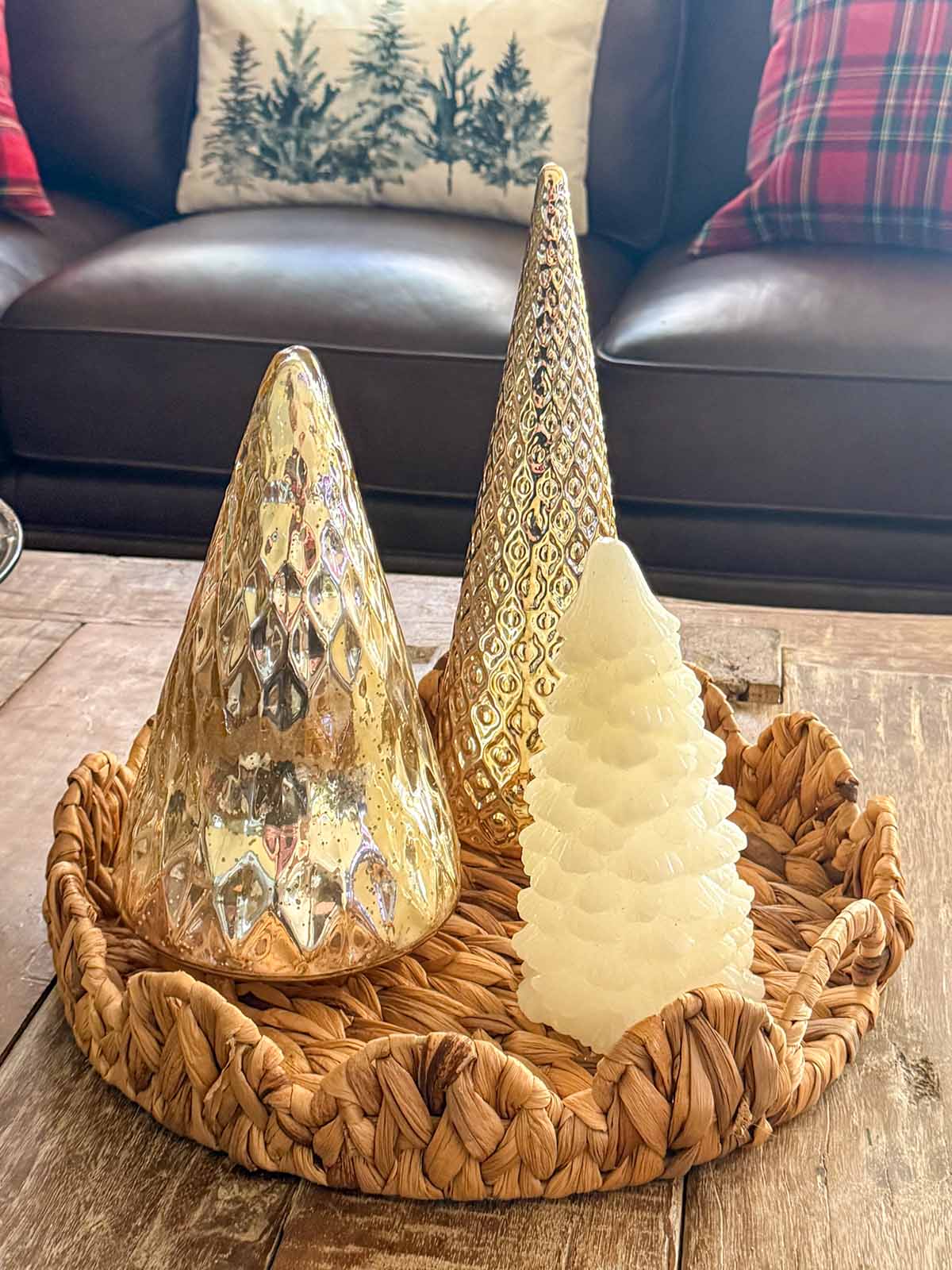 Interior design expert, journalist and lifestyle blogger Candie Anderson of candieanderson.com shares her scalloped woven tray adorned with metallic Christmas trees on her rustic coffee table in her living room.