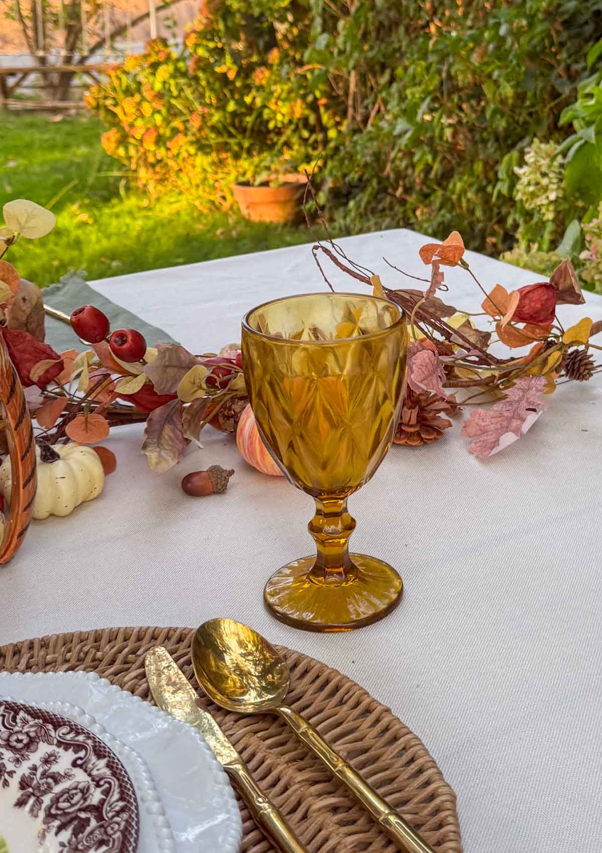 Entertaining expert, journalist and lifestyle blogger Candie Anderson of candieanderson.com shares the beautiful Thanksgiving tablescape she created! The amber goblets look amazing paired with the autumn garland, pheasant candleholders and equestrian plates.