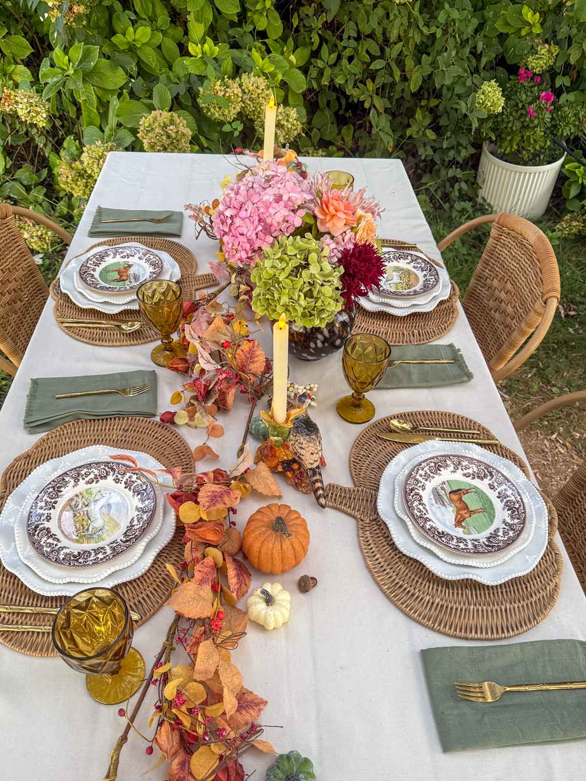 Entertaining expert, journalist and lifestyle blogger Candie Anderson shows her gorgeous Thanksgiving tablescape with pheasant candleholders, horse plates, gorgeous flowers, olive green napkins, pumpkin-shaped rattan placemats and more.
