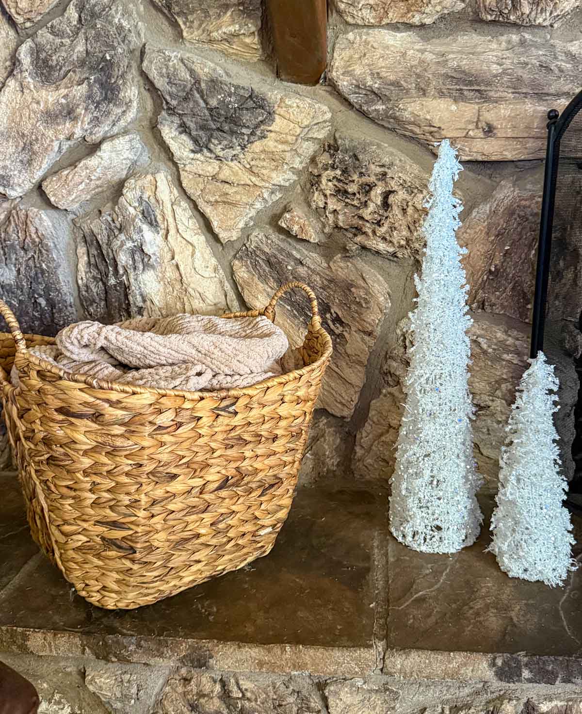 Lifestyle expert, journalist and interior design blogger Candie Anderson of candieanderson.com shares a beautiful woven basket adorned with a classic knit throw blanket on her holiday fireplace hearth.